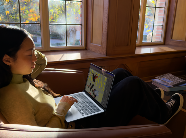 Una persona sentada en una silla usa una MacBook Air