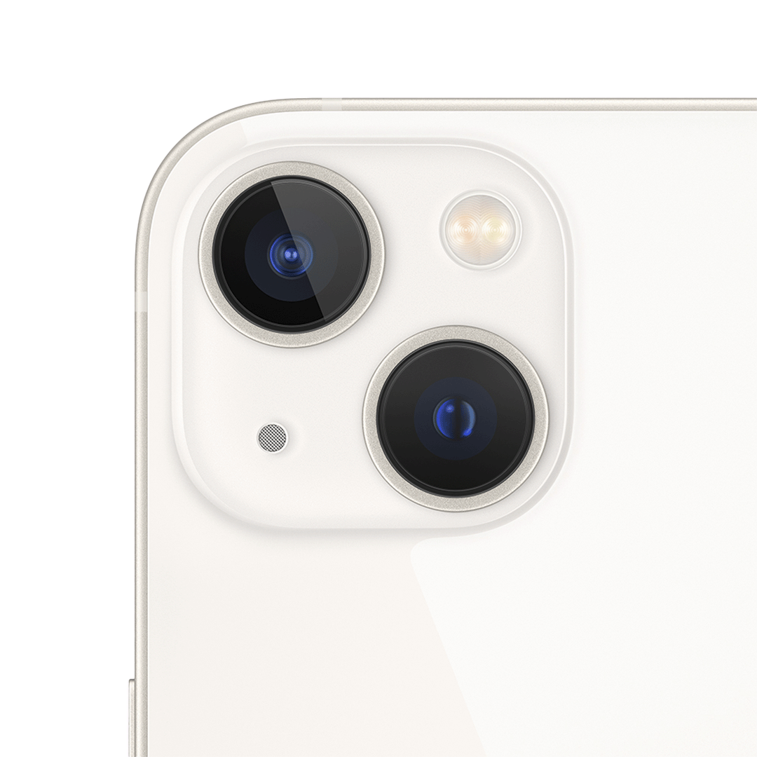 Vista cercana del sistema de doble cámara trasera del iPhone 13 en color blanco estelar, con lentes en disposición diagonal, micrófono y flash True Tone integrados en un módulo de bordes suaves.